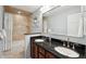 Bathroom featuring a double vanity with a black countertop and modern fixtures at 1998 S Harlan Ct, Lakewood, CO 80227