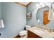 Powder bathroom with granite counter and round mirror at 1998 S Harlan Ct, Lakewood, CO 80227