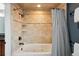 Bright bathroom featuring a soaking tub with tile surround and modern fixtures at 1998 S Harlan Ct, Lakewood, CO 80227