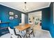 Stylish dining room features dark blue walls, contemporary light fixture, and a view into the living room at 1998 S Harlan Ct, Lakewood, CO 80227