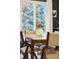 The dining room table is set beautifully with light colored dining chairs and view of a window at 1998 S Harlan Ct, Lakewood, CO 80227