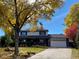 Charming two-story home with a well-manicured lawn, mature trees, and a welcoming front entrance at 1998 S Harlan Ct, Lakewood, CO 80227