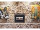 Stone fireplace with wooden mantle and hearth, flanked by artwork at 1998 S Harlan Ct, Lakewood, CO 80227