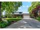 Charming two-story home features a manicured lawn, brick accents, and an attached two-car garage at 1998 S Harlan Ct, Lakewood, CO 80227