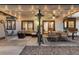 Inviting covered patio with comfortable seating, ceiling fan, ambient lighting, and access to the home's interior at 1998 S Harlan Ct, Lakewood, CO 80227