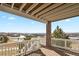 Large covered balcony with brick pillar, white railing, and scenic neighborhood views at 20132 Spruce Point Pl, Parker, CO 80134