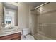 Bathroom featuring a shower with glass door, clean white toilet and a sink with wood vanity at 20132 Spruce Point Pl, Parker, CO 80134