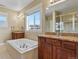 Luxurious bathroom featuring dual sinks, granite counters, a soaking tub, and a separate shower at 20132 Spruce Point Pl, Parker, CO 80134