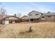 View of the spacious backyard and covered patio with a partial brick facade at 3765 S Depew St, Denver, CO 80235
