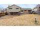 View of the spacious backyard and covered patio with a partial brick facade at 3765 S Depew St, Denver, CO 80235