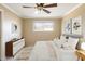 Inviting bedroom with ceiling fan, bright window, white linens, and decorative wall art at 3765 S Depew St, Denver, CO 80235