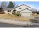 Charming two-story home with an attached two-car garage, a tidy lawn, and appealing brick accents at 3765 S Depew St, Denver, CO 80235