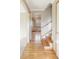 Bright hallway with polished hardwood floors leading to a staircase and other rooms in the house at 3765 S Depew St, Denver, CO 80235