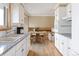 Charming kitchen with white cabinets, granite countertops, and a view of the dining area at 3765 S Depew St, Denver, CO 80235
