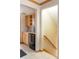 Convenient kitchenette with wooden cabinets, mini fridge, and sink, next to the stairs at 3765 S Depew St, Denver, CO 80235