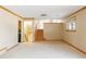Spacious living room with a stairway, light-colored walls, and neutral carpeting at 3765 S Depew St, Denver, CO 80235
