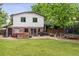 Expansive backyard featuring mature trees, a trampoline, hot tub, and wooden deck for outdoor entertaining at 5987 W Ken Caryl Pl, Littleton, CO 80128