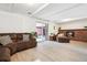 Spacious finished basement with a brick fireplace, plush seating, and sliding glass doors at 5987 W Ken Caryl Pl, Littleton, CO 80128