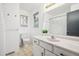 Bright bathroom featuring a white vanity with granite countertop, updated fixtures, and natural light at 5987 W Ken Caryl Pl, Littleton, CO 80128