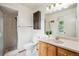 Bathroom with a walk-in shower, oak vanity and mirror with ample lighting at 5987 W Ken Caryl Pl, Littleton, CO 80128