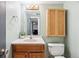 Bathroom with vanity, wood cabinet, mirror, toilet, and light green walls at 5987 W Ken Caryl Pl, Littleton, CO 80128