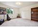 Spacious bedroom with natural light, neutral carpet, and large bookshelf ready to be transformed into your personal space at 5987 W Ken Caryl Pl, Littleton, CO 80128