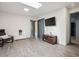 Bonus room with hardwood floors, large windows, tv, and storage bench at 5987 W Ken Caryl Pl, Littleton, CO 80128