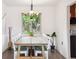 Dining area with wooden table, white chairs, chandelier, and natural light from the window at 5987 W Ken Caryl Pl, Littleton, CO 80128