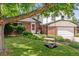 Lovely two-story home boasting a lush green lawn, mature trees, and charming curb appeal at 5987 W Ken Caryl Pl, Littleton, CO 80128