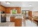 Traditional kitchen with wooden cabinets, granite countertops, and an island with bar seating at 5987 W Ken Caryl Pl, Littleton, CO 80128