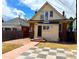 Exterior of the home featuring a back entrance, small yard, red brick and yellow siding at 52 S Washington St, Denver, CO 80209