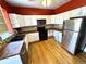 Functional kitchen featuring white cabinets, wood countertops, and stainless steel appliances at 52 S Washington St, Denver, CO 80209