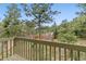 Backyard scene with mature trees, and a play structure on the grass at 1185 Fawnwood Rd, Monument, CO 80132