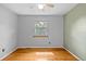 Bright bedroom featuring hardwood floors, a ceiling fan, and a window with wooded views at 1185 Fawnwood Rd, Monument, CO 80132