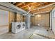 Unfinished basement laundry area with visible ductwork and a modern washer and dryer at 1185 Fawnwood Rd, Monument, CO 80132