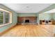 Bright living room boasts large windows, hardwood floors, and brick fireplace at 1185 Fawnwood Rd, Monument, CO 80132