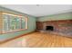 Cozy living room with hardwood floors, brick fireplace, and bright window at 1185 Fawnwood Rd, Monument, CO 80132