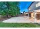 Exterior view of a backyard featuring an expansive concrete patio and well-manicured lawn at 15918 E Flora Pl, Aurora, CO 80013