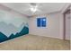 Comfortable bedroom featuring a nature-themed accent wall and a well-lit window at 15918 E Flora Pl, Aurora, CO 80013