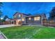 Rear view of a two-story home showcasing a vast backyard, lawn and a spacious patio at 15918 E Flora Pl, Aurora, CO 80013