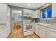 Functional kitchen with white appliances, white cabinetry, and views into the dining area at 15918 E Flora Pl, Aurora, CO 80013
