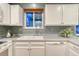 Bright kitchen features white cabinetry, dual basin sink and a window view at 15918 E Flora Pl, Aurora, CO 80013