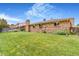 Large backyard with lush lawn and brick home exterior at 2180 S Flower Way, Lakewood, CO 80227