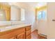 Well lit bathroom featuring a wood vanity, sink, and vintage wallpaper at 2180 S Flower Way, Lakewood, CO 80227