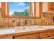 Kitchen sink with window view, wood cabinets, and tiled backsplash at 2180 S Flower Way, Lakewood, CO 80227