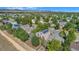 Aerial view of neighborhood showcasing a home with solar panels surrounded by mature trees at 1624 Westin Dr, Erie, CO 80516