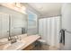 Neutral bathroom offers sink, large mirror, toilet and shower with white curtain at 1624 Westin Dr, Erie, CO 80516