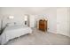 Bright bedroom featuring soft gray carpet, a cozy queen bed and a wooden dresser at 1624 Westin Dr, Erie, CO 80516