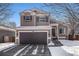 Two-story home with a two-car garage, light brown siding, and unique dark brown window shutters at 1624 Westin Dr, Erie, CO 80516