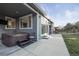 Back patio features a hot tub, large windows and sliding glass doors and a concrete walkway to the backyard at 2198 Broadleaf Loop, Castle Rock, CO 80109